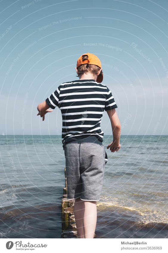 Junge balanciert auf Pollern in der Ostsee junge kind schuljunge eine person kinder balance spaß meer wasser wellen poller brandung küste urlaub ferien sommer