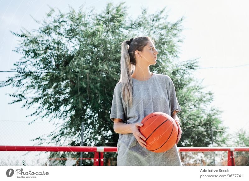 Selbstbewusster Basketballspieler auf dem Spielplatz stehend Frau selbstbewusst Sport Gericht wettbewerbsfähig ernst jung Sportlerin Ball Athlet Sportbekleidung