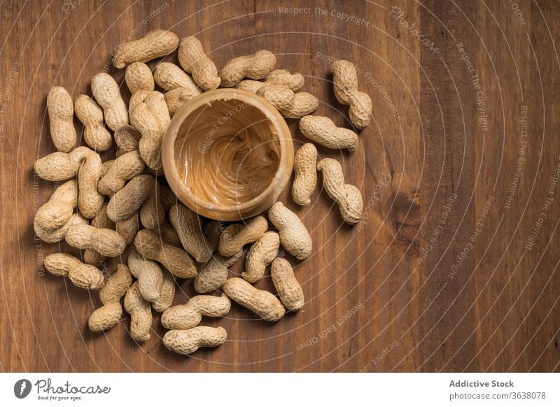 Köstliches Glas mit Erdnussbutter auf Holztisch Butter lecker Frühstück Lebensmittel geschmackvoll Ernährung Tisch hölzern Küche Mahlzeit Gesundheit Morgen