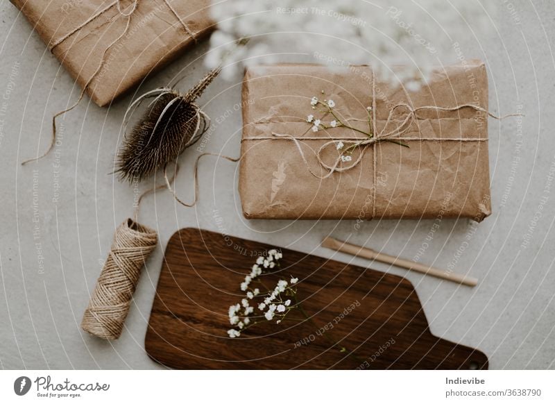 Geschenk verpackt in umweltfreundlichem Recyclingpapier mit Trockenblumen und Schnur umhüllen diy Hintergrund beige Überraschung Weihnachten Geburtstag Kasten