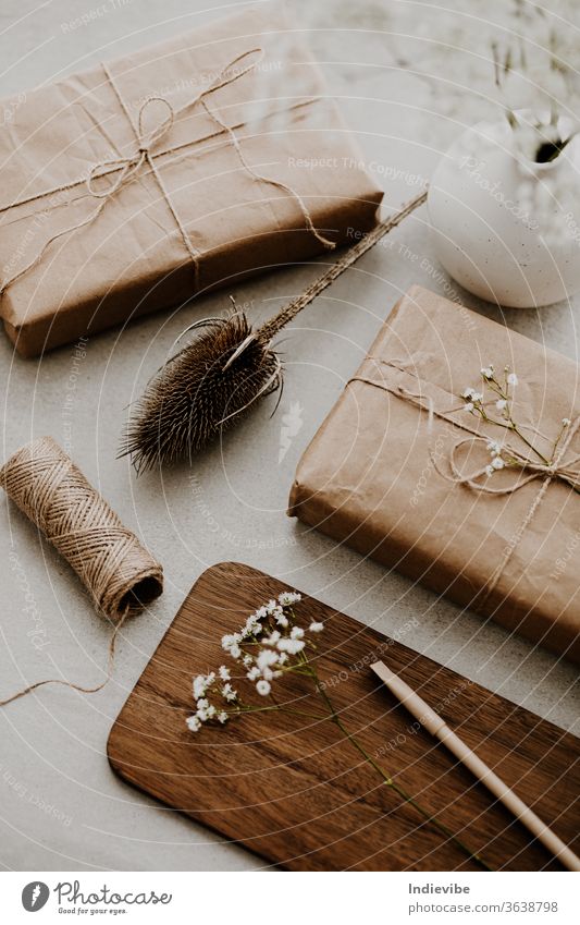 Geschenk verpackt in umweltfreundlichem Recyclingpapier mit Trockenblumen und Schnur umhüllen diy Hintergrund beige Überraschung Weihnachten Geburtstag Kasten