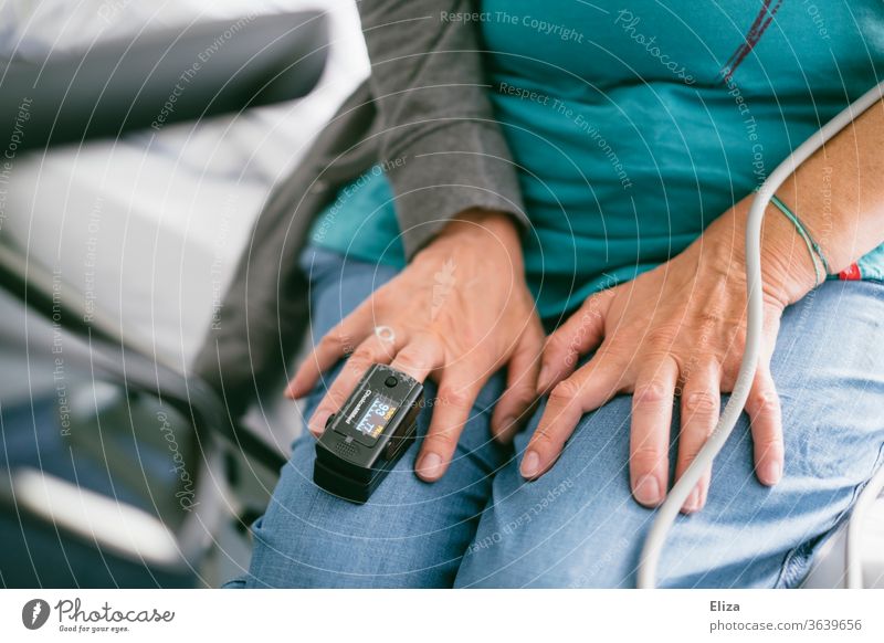 Eine Frau im Krankenhaus mit einem Pulsoximeter, zur Messung des Pulses und der Sauerstoffsättigung im Blut, am Mittelfinger pulsmessung Untersuchung