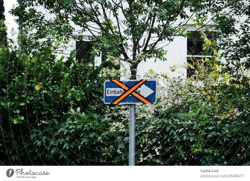 Ein etwas älteres Einbahnstraßen-Schild wird derzeit nicht benötigt und wurde deshalb leuchtend orange beklebt Strassenschild durchgestrichen skurril X