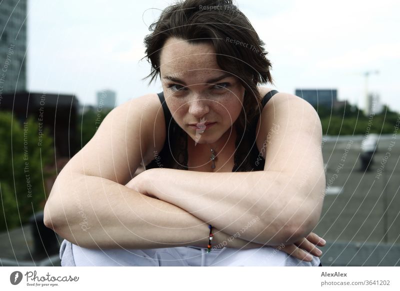 Portrait einer jungen, sommersprossigen Frau auf einem Dach junge Frau Top Haare brünett schön intensiv Jugendliche 18-25 Jahre Blick in die Kamera weiblich