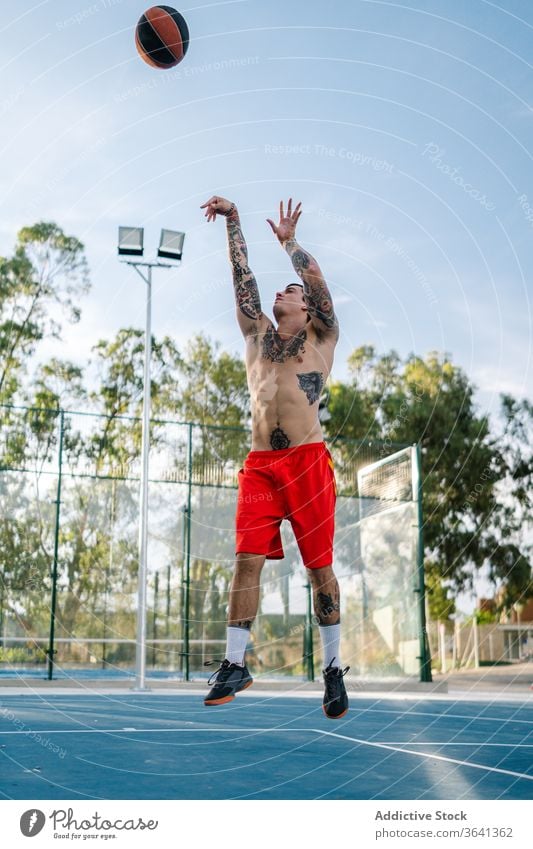 Männlicher Basketballspieler trainiert auf dem Spielplatz Spieler spielen Mann Tattoo Sportler Training männlich Energie Gesundheit sportlich muskulös Straße