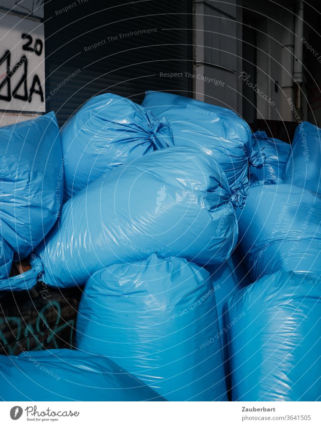 Blaue Müllsäcke aus Plastikfolie stapeln sich auf der Straße Müllsack Abfall Stapel wegwerfen Umwelt Müllentsorgung Recycling entsorgen prall Falten Müllabfuhr