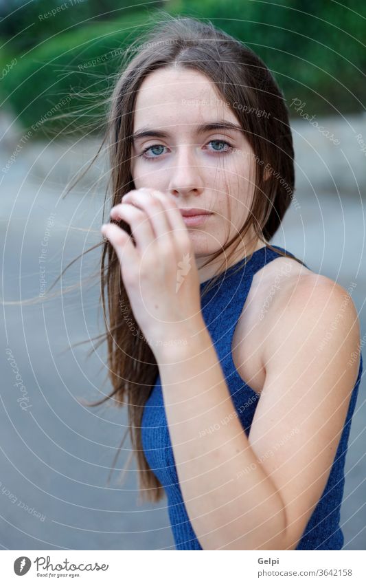 Süßes Teenager-Mädchen mit langen und glatten Haaren Behaarung Natur Deckung Gesicht jung Frau besinnlich außerhalb schön Wind Porträt Menschen attraktiv Mode