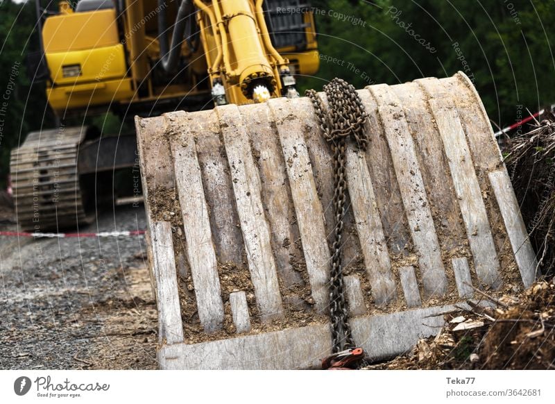 große Baggerschaufel auf einer Baustelle Großbagger gelber Bagger schaufeln große Schaufel Beton Hausbau Erde Erdbewegungsmaschine ein Haus bauen Bauarbeiten