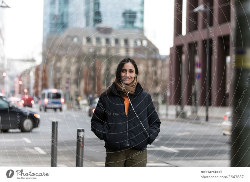 Attraktive junge indische Frau posiert an Straßenecke Junge Frau Ethnie der Indianer Musik Kopfhörer mittlere Aufnahme Hörbuch hören Fokus auf den Vordergrund