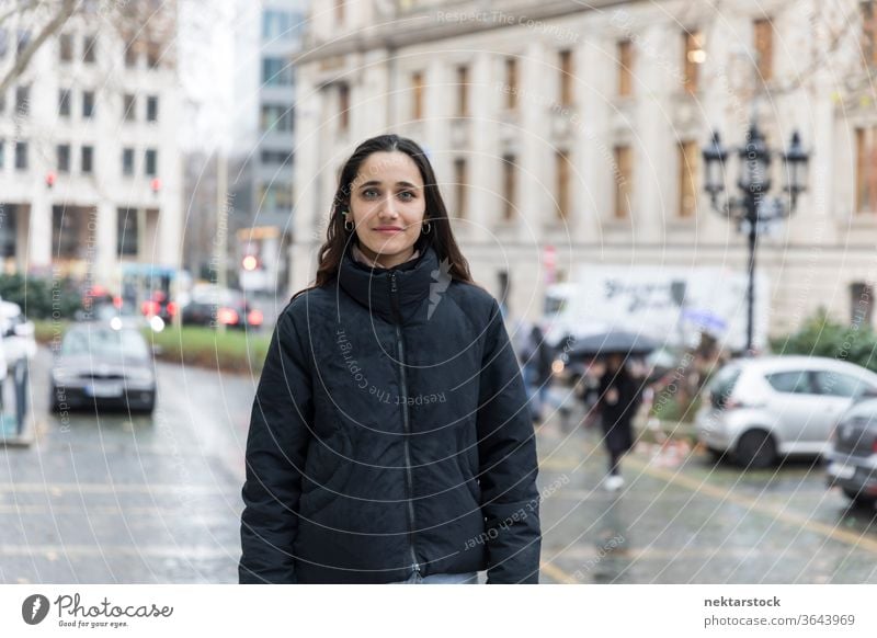 Junge indische Stadtbewohnerin, die in der Stadt posiert und in die Kamera schaut. Junge Frau Ethnie der Indianer mittlere Aufnahme Fokus auf den Vordergrund