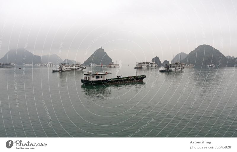 Boote in der Halong-Bay, Vietnam Schifffahrt viele Regen Wetter Außenaufnahme Farbfoto Wasser Kälte schwarz dunkel Textfreiraum oben Nebel exotisch Schatten