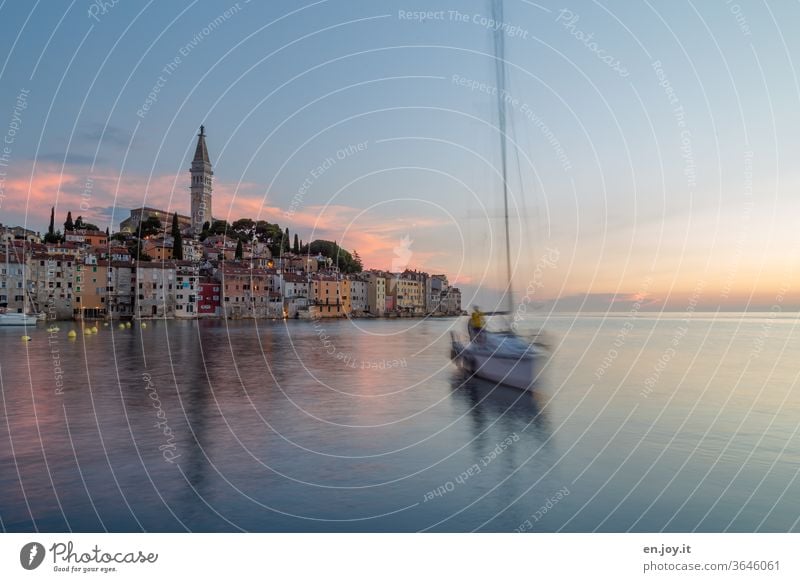 ein schnelles Segelschiff ohne Segel segelt mit hoher Geschwindigkeit frontal auf mich zu...es kommt wohl direkt von Rovinj, das im Hintergrund seine Farben in der untergehenden Sonne erstrahlen lässt. Hoch über der Altstadt ragt der Kirchturm heraus.