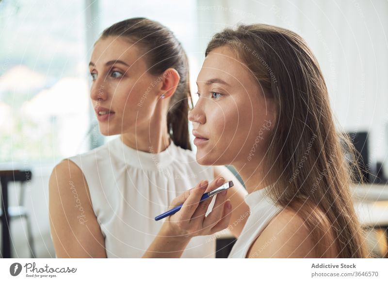 Stylistin beim Auftragen von Eyeliner auf das Modell visagiste Bürste Make-up Atelier Augenbrauen Fokus bewerben Konzentration Klient jung Beruf Kosmetik Pflege