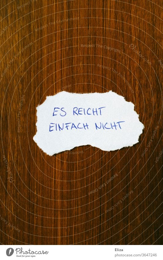 Ein Zettel auf dem “Es reicht einfach nicht” steht. Armut Geldsorgen Geldknappheit zu wenig es reicht nicht Knappheit Mangel Gefühle Trennung Schluss machen