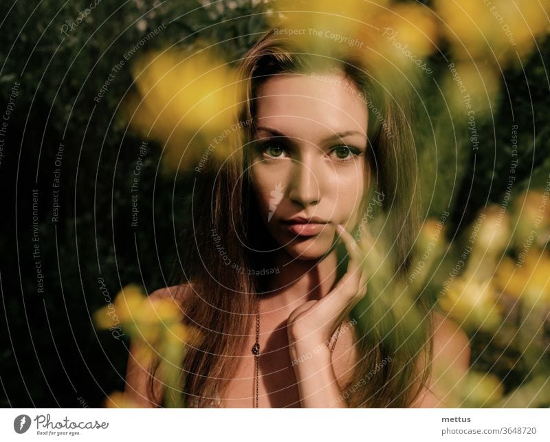 Nachdenkliche Blondine in einem Sommerfeld mit verschwommenen Blumen im Vordergrund, Fokus auf das Gesicht blond Kleid Schnappschuss schön Feld Mode Frühling