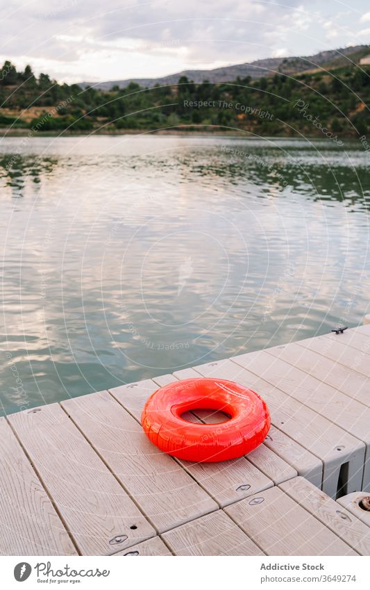 Gummiring am Pier in der Nähe des Sees Ring aufblasbar Teich Kai majestätisch Sonnenuntergang Sommer Wasser ruhig Urlaub Feiertag Natur hölzern Abenddämmerung