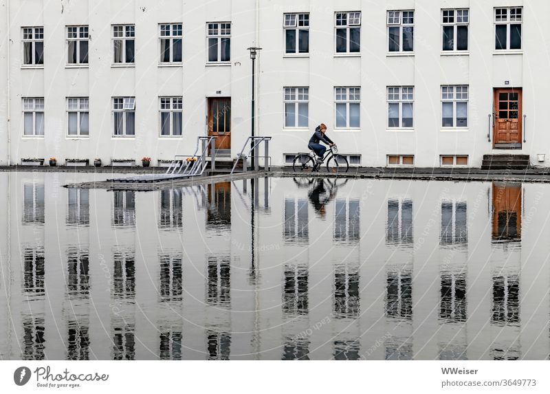 Morgens in Reykjavik Fahrrad Spiegelung Radfahrerin Fenster Fassade Pool Becken Wasser Türen Eingang Außenaufnahme Island Mütze Reykjavík Reflexion & Spiegelung