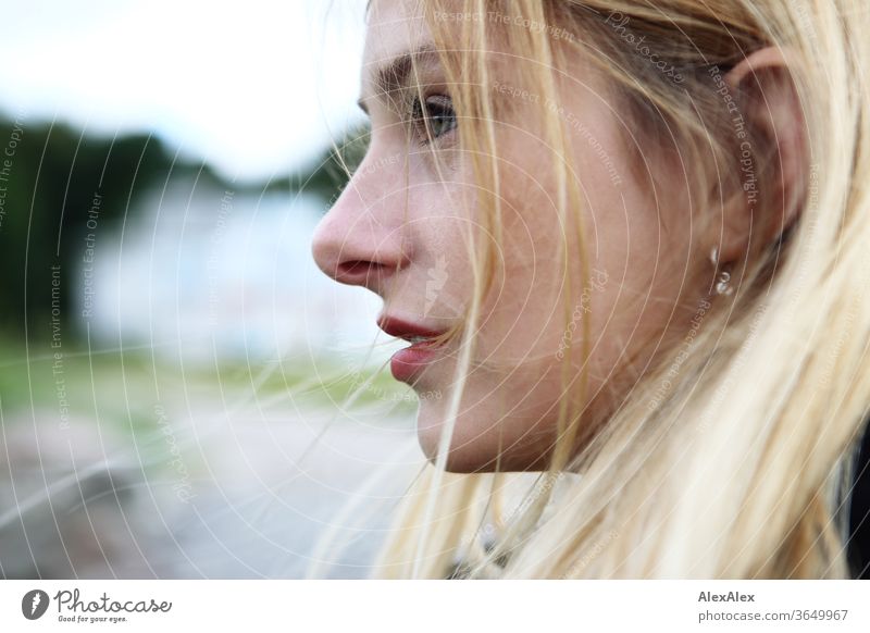 Seitliches Portrait einer jungen, blonden Frau junge Frau schön schlank seitlich langhaarig windig rote Lippen ästhetisch Sommer Ausflug Schönes Wetter Model