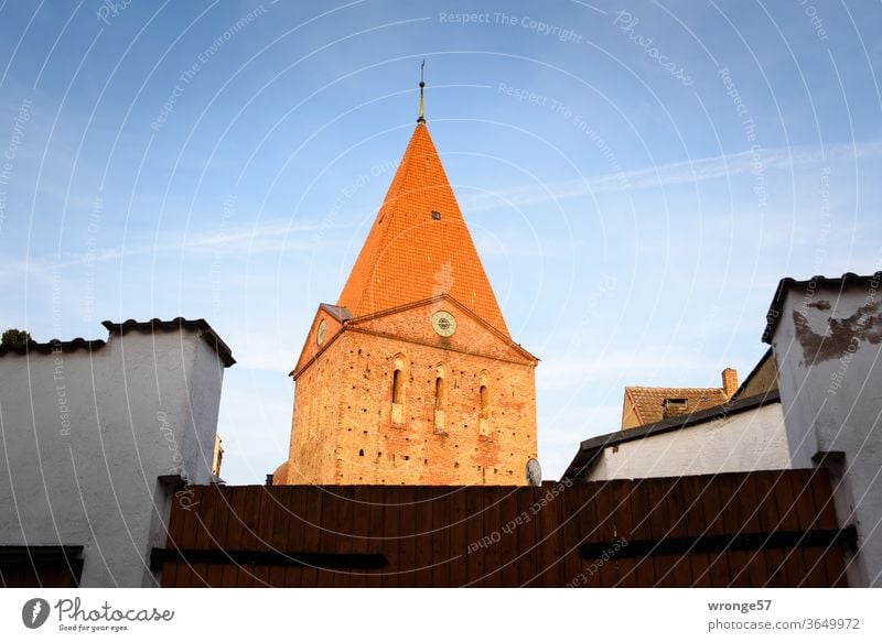 Kirchturm der Schwaaner St. Paulus Kirche hinter einem Hoftor Ortsmitte Außenaufnahme Farbfoto Menschenleer Architektur Religion & Glaube Sehenswürdigkeit