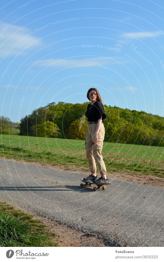 Junge Frau läuft Schlittschuh auf einer Straße in der Natur Porträt sportlich genießend Mode Tag Schönheit Schlittschuhlaufen Hand modern attraktiv Mädchen