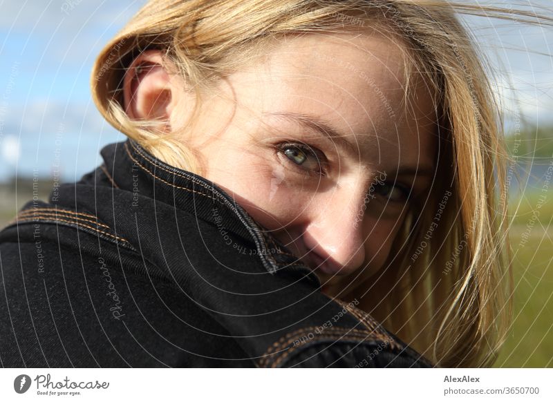 Seitliches Portrait einer jungen, blonden, lächelnden Frau junge Frau schön schlank seitlich langhaarig windig ästhetisch Sommer Ausflug Schönes Wetter Model