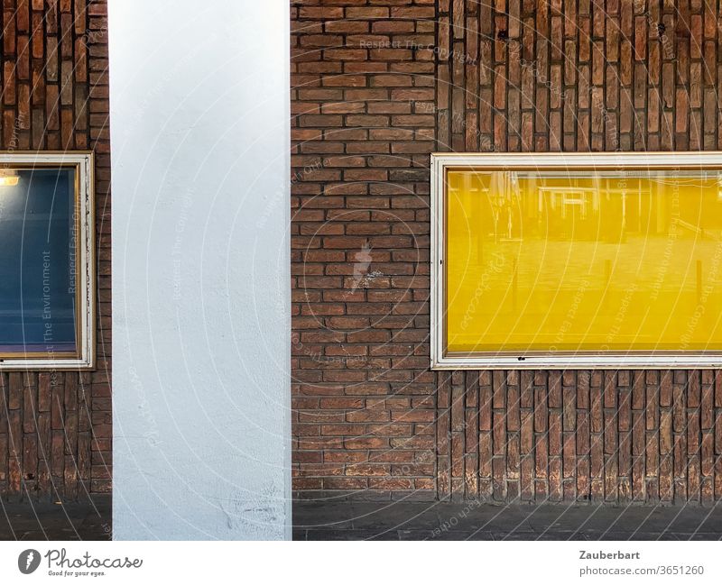 Fenster mit gelbem und blauem Hintergrund, Fassade aus Ziegeln und Betonpfeiler horizontal vertikal Pfeiler Architektur abstrakt geschichtet Strukturen & Formen