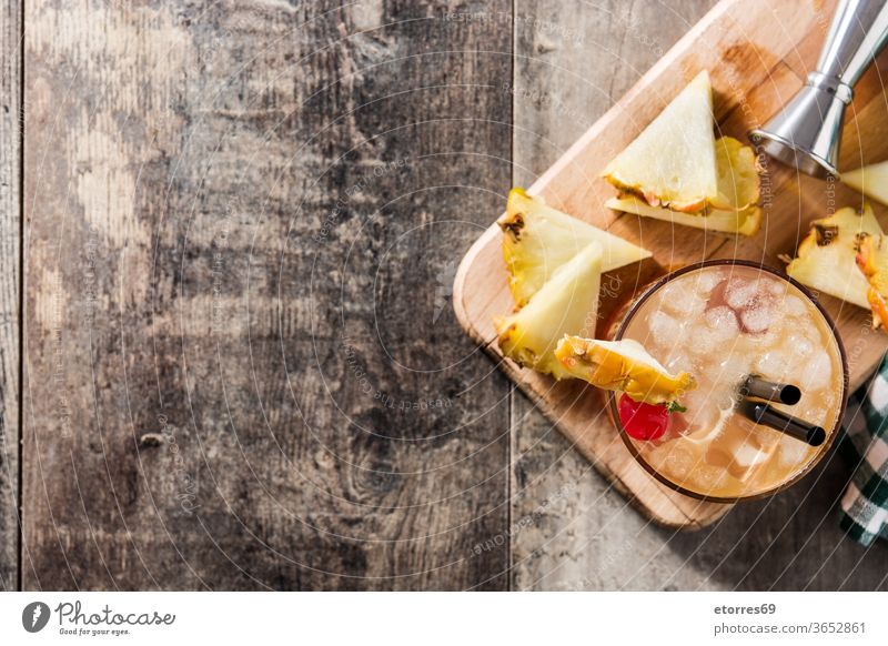 Kalter Mai-Tai-Cocktail mit Ananas und Kirsche auf Holztisch. Ansicht von oben. Raum kopieren alkoholisch Getränk Schnaps kalt lecker trinken Lebensmittel