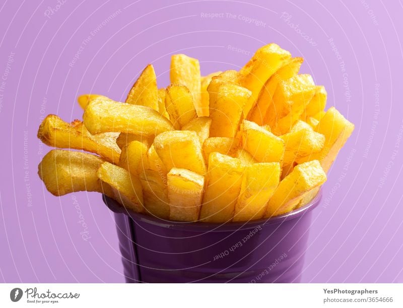 Pommes Frites in Nahaufnahme. Frittierte Lebensmittel. Pommes Frites auf violettem Hintergrund Amerikaner Kalorien Chips Cholesterin Knusprig Küche frittiert