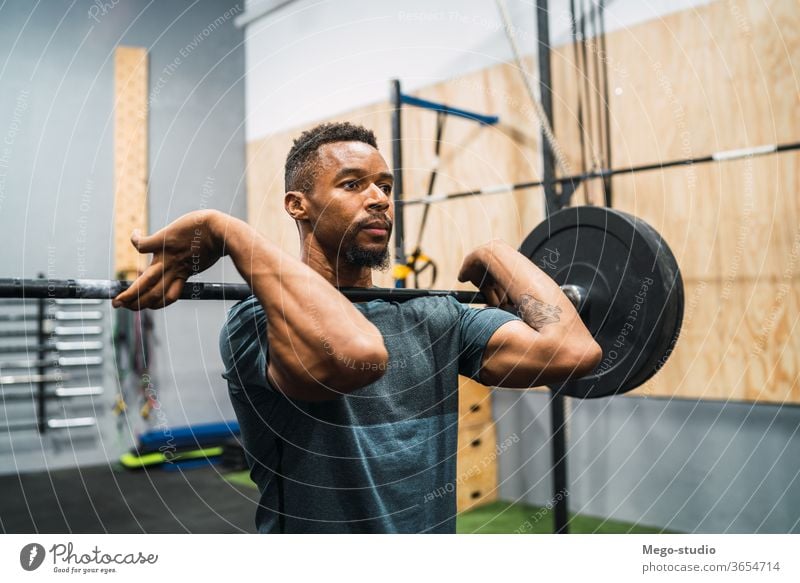 Crossfit-Sportler, der mit einer Langhantel trainiert. Mann Fitness Curl-Hantel Training Übung Muskeln Konzentration Crossfit-Training sportlich Konzept