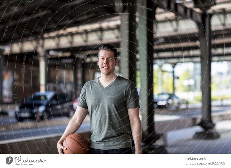 Mann mit Basketball unter Stadtbrücke stehend Erwachsener Kaukasier urban gutaussehend Model eine Person Frontseite in die Kamera schauen Straße Verkehr