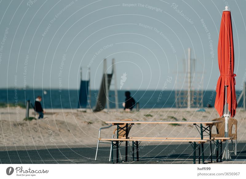 roter Sonnenschirm geschlossen am Strand Roter Sonnenschirm Spielgeräte Rutsche Küste Sand Sommerurlaub Schönes Wetter Insel Nordsee Ostsee Wasser Meer Natur