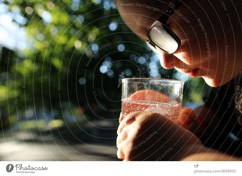 Junge, der sprudelndes Wasser in einem Glas beobachtet beobachten Beobachter Blick Wachsamkeit neugierig Neugier Licht funkelnd Zen Beteiligung Achtsamkeit