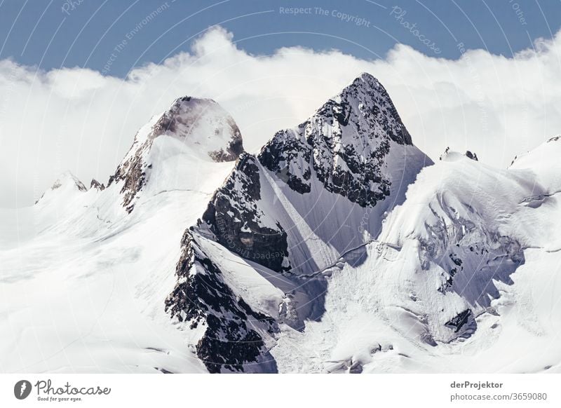 Bergspitzen mit Schnee in der Sonne und mit Wolke im Gebirge in Engadin Bergsteigen weiß blau Freiheit Wolken Wolkenformation Berge u. Gebirge wandern