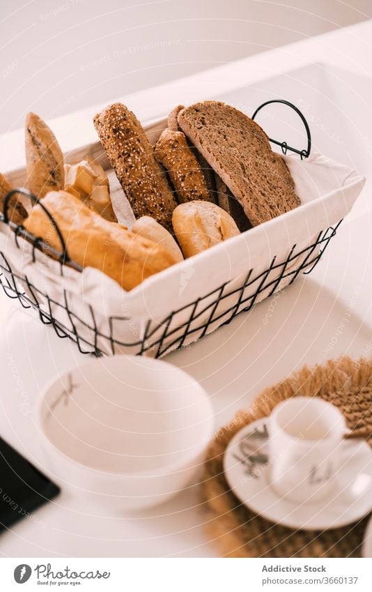 Tisch mit frischem Gebäck zum Frühstück Geschirr Kulisse Porzellan Brot Morgen Komfort heimwärts Kaffee Tasse gemütlich Licht Lebensmittel Mahlzeit dienen