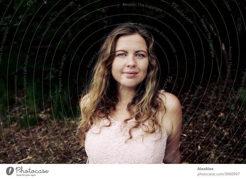 Nahes Portrait einer jungen Frau vor einem Wald lockig Reinheit Glück Schönes Wetter Ausflug Erwartung Sonnenlicht Freude Nahaufnahme feminin Tag