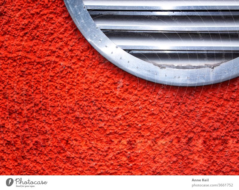 Knallige rot orangene Hauswand mit rundem Lüftungsgitter Fassade Außenaufnahme Wand Farbfoto Menschenleer Tag Mauer Rot Orange silber Gitter Metall