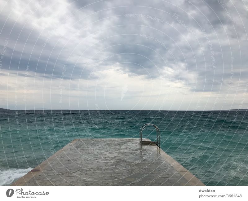 Schwimmen im Sturm wellen Wellen Meer Wasser Küste Strand Wind Wolken Gischt Himmel Außenaufnahme Menschenleer Natur Farbfoto Horizont Unwetter Brandung Tag