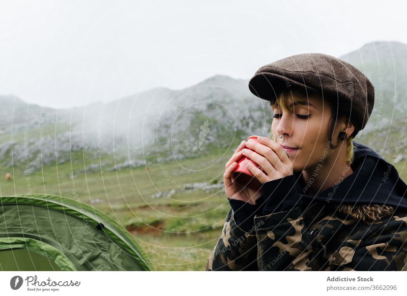 Frau in Oberbekleidung in der Nähe eines Campingzeltes in der Natur Lager Zelt Hochland Inhalt sich[Akk] entspannen Reisender Morgen Fernweh Freiheit Landschaft