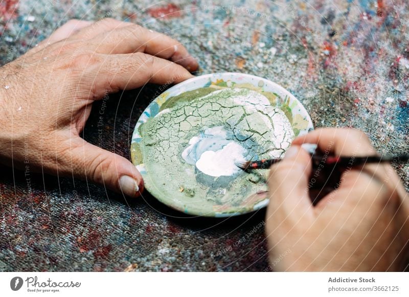 Fokussierter Künstler beim Mischen von Farben in einer Palette Mischung mischen Kunst Werkstatt Kleinunternehmen Konzentration Pigment Atelier Beruf Wasserfarbe