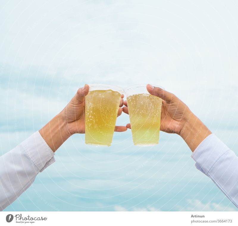 Party feiern, Hände halten Getränkebiere mit Plastikgläsern und jubeln über den Erfolg mit einem schönen Himmel als Hintergrund Erwachsener Alkohol alkoholisch