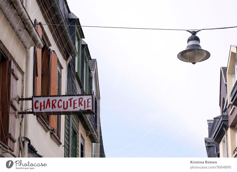 charcuterie metzger metzgerei schlachter schlachterei schild leuchtschild leuchtreklame werbeschild werbung typo schrift häuser gebäude straßenlaterne dorf ort