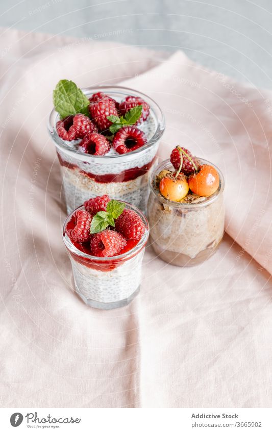 Glasgläser mit Pudding mit Chiasamen und verschiedenen Beeren Frühstück gesunde Ernährung Samen Himbeeren Marmelade Kirsche süß Supernahrung lecker