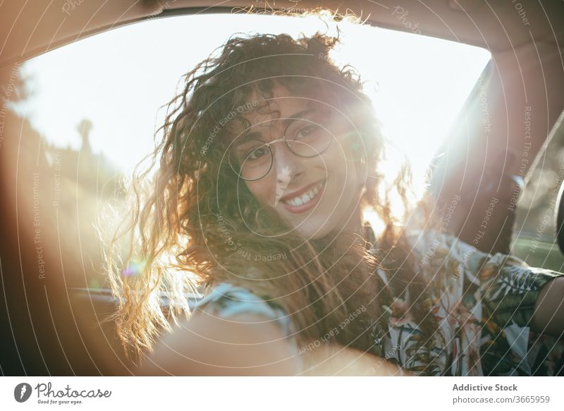 Glückliche Frau im Auto PKW Sonnenschein heiter Zahnfarbenes Lächeln Freude positiv Wochenende feminin Brille charmant genießen froh lässig anhaben Sommer