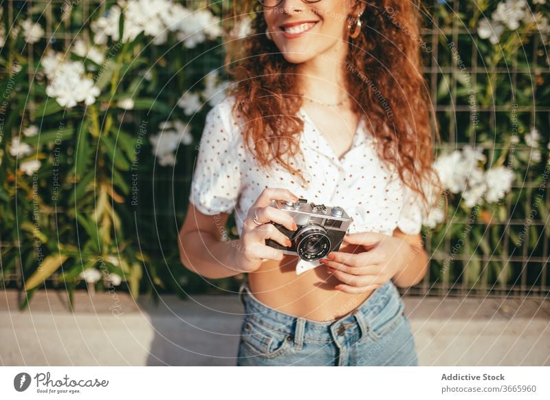 Glückliche Frau, die draussen mit der Kamera fotografiert fotografieren Fotoapparat digital Moment Sonnenschein heiter benutzend Gerät Hobby