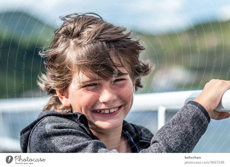 stürmische zeiten frech lange Haare Farbfoto Familie Nahaufnahme Kind Junge Kindheit Gesicht Tag Licht Kontrast Porträt Sonnenlicht Haare & Frisuren Mund Lippen