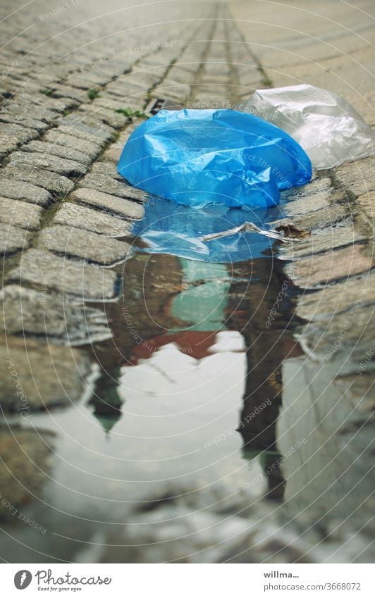 die welt versinkt in plastik Plastiktüte Plastikmüll Pfütze Umweltverschmutzung Rathaus Spiegelung Pflastersteine Kunststofftüte Plastetüte Kunststoffprodukt