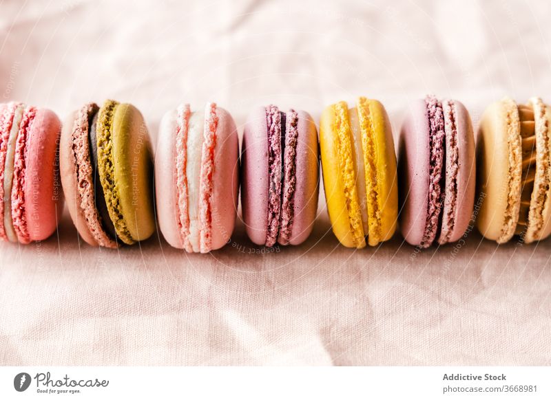 Set aus verschiedenen Makronen auf Tisch mit Blumen Biskuit sortiert Macaron Dessert süß Linie Leckerbissen Lilien frisch Blüte Blütezeit lecker schmackhaft