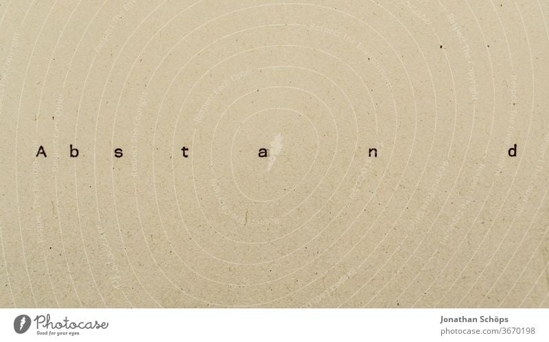 Abstand als Text auf Papier mit Schreibmaschine Abstandsregel Anstand Corona Coronakrise Coronavirus Covid-19 Infektionsschutz Recycling Rücksicht Schrift