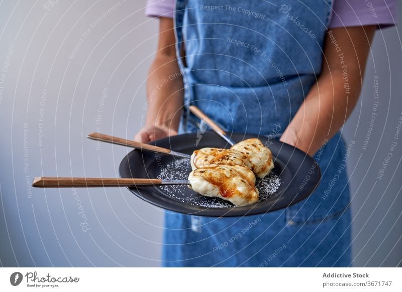 Crop-Frau mit Portionen von Crème brulee auf Teller Dessert lecker Creme Brulee Zucker Koch selbstgemacht geschmackvoll gebacken süß Gebäck Schürze heimwärts