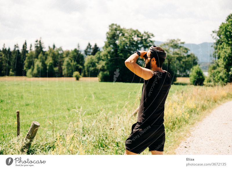 Mann beobachtet etwas durch ein Fernglas in der Natur beobachten suchen Abenteuer Landschaft Sommer Ferne Blick entdecken Aussicht Tourismus Neugier Erwachsene